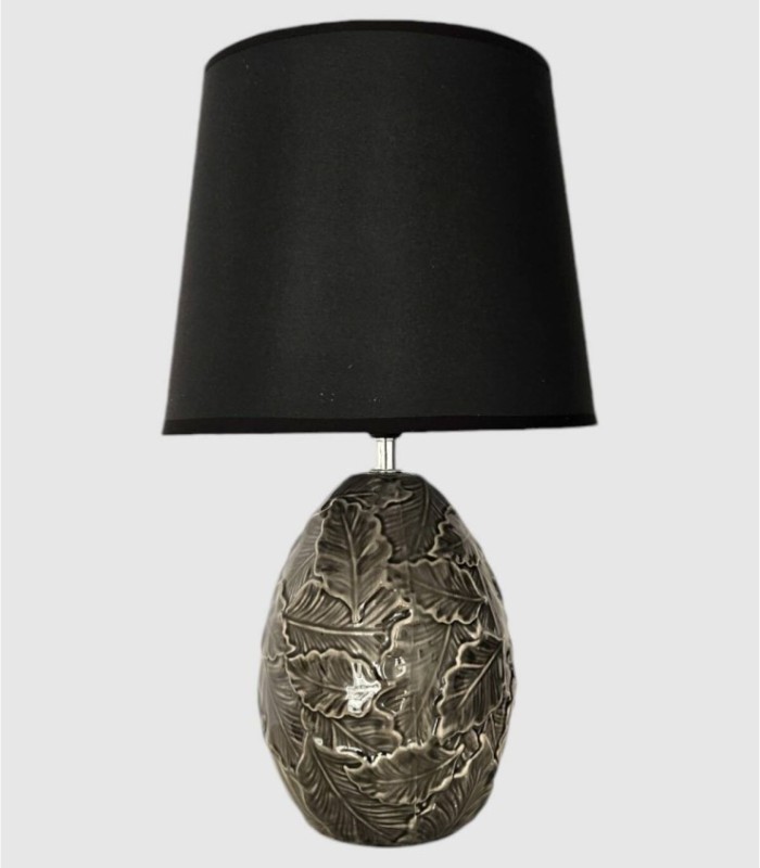 Tafellamp met decoratieve bladvoet en zwarte kap.